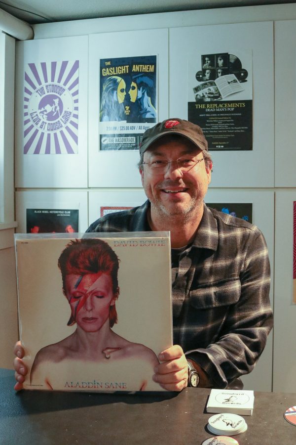Jason Gorbett, owner of Songbyrd Records, smiles while holding David Bowie’s Aladdin Sane, one of his favorite artists’ albums March 18. “When I was a teenager, I had some pretty rough times and music really saved my life,” Gorbett said. “Local record stores were places that I could go that were safe, where I could learn about things, where I could meet other weirdos like me, and discover the world.” Gorbett sees great importance in continuing to keep vinyls and record stores alive in our current society because, “they transcend time and space and culture… they are the universal ambassadors of joy.”