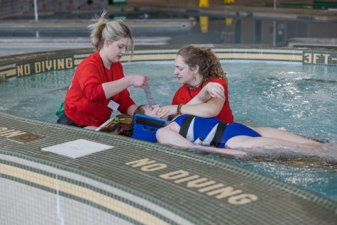 Colorado State University lifeguards Annie Scott and Paige Foster perform a simulated rescue on Megan Mullin during lifeguard audits at the CSU Recreation Center March 20.