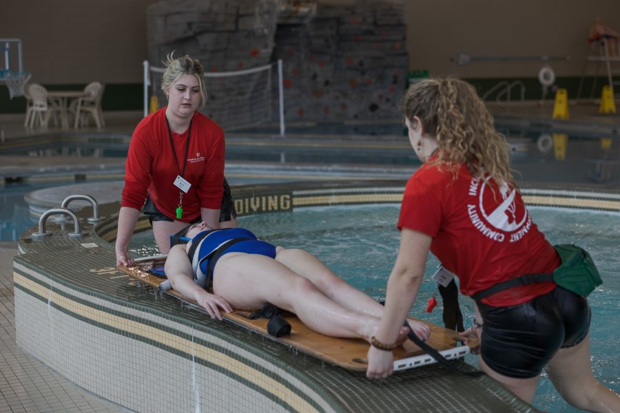 Colorado State University lifeguards Annie Scott and Paige Foster perform a simulated rescue on Megan Mullin during lifeguard audits at the Campus Recreation Center March 20.