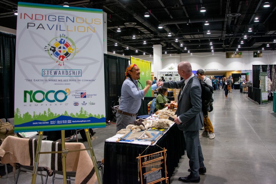 A vendor and expo attendee fist-bump on day three in the Indigenous Pavilion section of the NoCo Hemp Expo at The Broadmoor hotel in Colorado Springs, Colorado, March 31. 