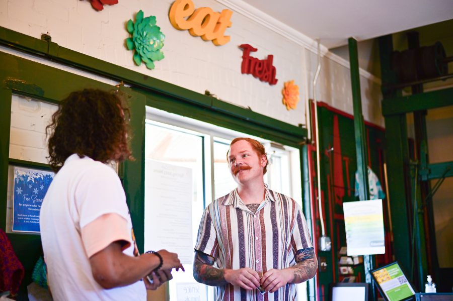 Lawrence Hermance, administrative assistant and grant writer, talks with Nicholas Kullin, a musician and spiritual entrepreneur from New Jersey at FOCO Cafe April 1. 