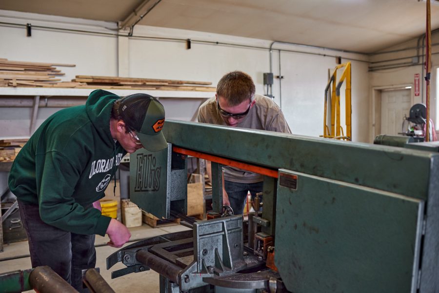 Charles Moore, sophomore mechanical engineering student, and Nicholas DeBey, first-year computer engineering student, cut a part on a horizontal band saw at the Engineering Research Center March 4. Members of Ram Racing use caution while operating power tools to avoid injury.