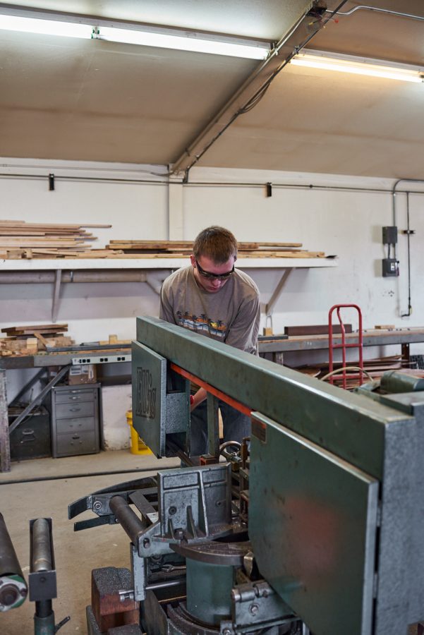 Nicholas DeBey, first-year computer engineering student, cuts a part on a horizontal band saw at the Engineering Research Center March 4. Students use caution while operating power tools to avoid injury.