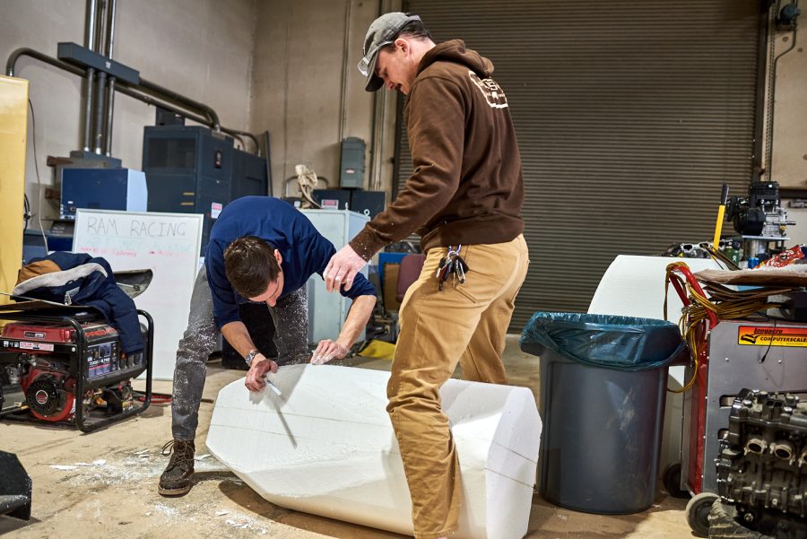 Connor Shelton and Tim Hunt, senior mechanical engineering students, shape the styrofoam mold for the nose cone of the Ram Racing vehicle March 4. The styrofoam mold was used to create a carbon fiber nose for the vehicle.