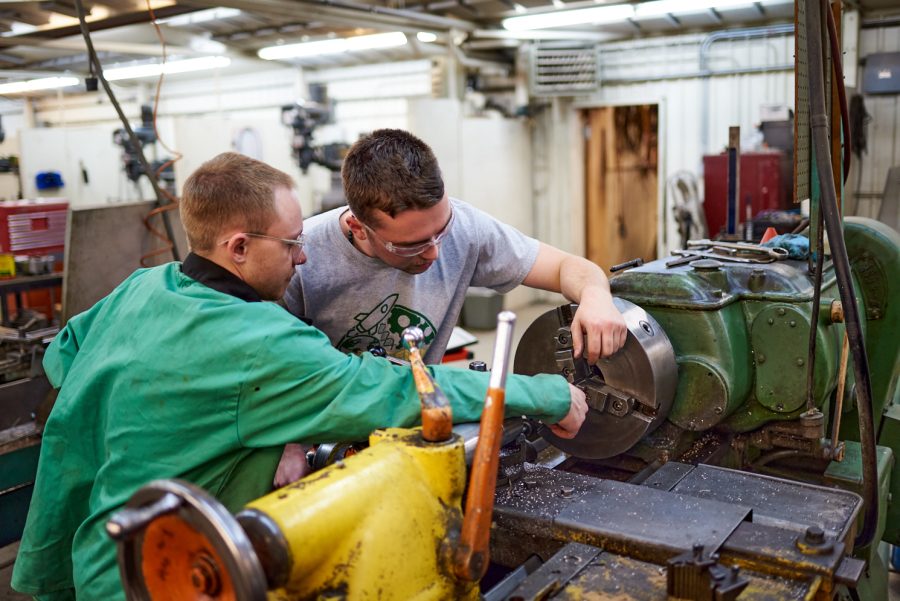 Brennan Burris, Ram Racing technical director and suspension lead, and Oscar Wenham, Ram Racing president, connect machine parts on a metal lathe at the Engineering Research Center Jan. 28. Burris and Wenham operated the lathe safely by only touching the moving components of the lathe when it was not powered on.