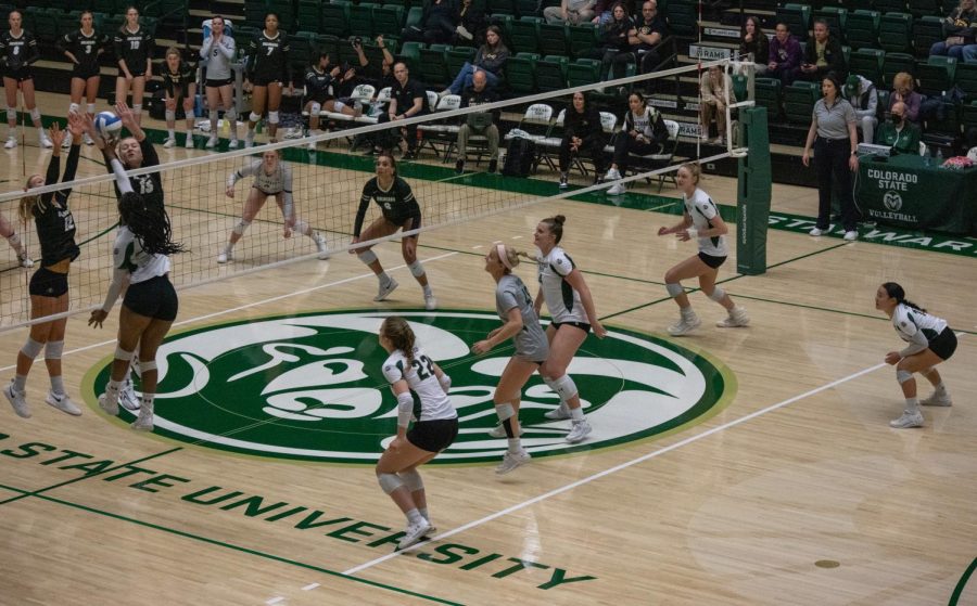 Outside hitter, Kennedy Stanford strikes the ball to earn a point for her team. Her teammates close behind for backup.