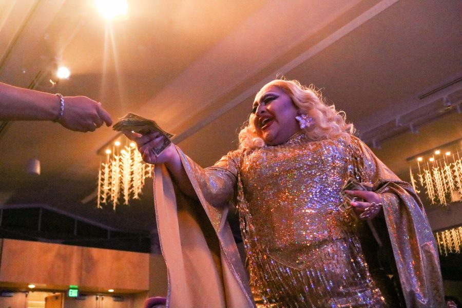 Natalia Wynters takes a cash donation from an audience member while performing to Night of Your Life by David Guetta featuring Jennifer Hudson at the drag show April 9.