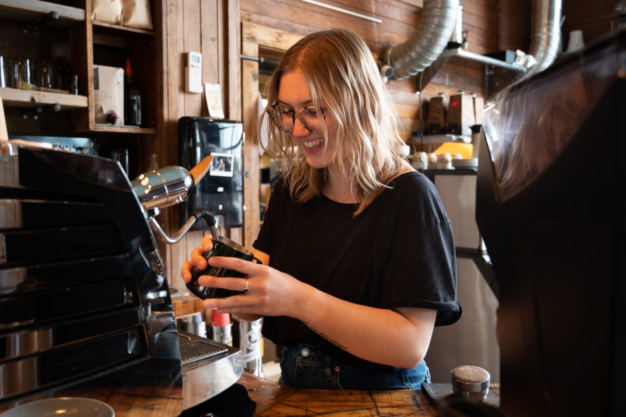 Savannah Wood, a barista at Bindle Coffee in Fort Collins, CO, steams milk to make a cappuccino at their Jessup Farms location, Apr 18. Wood has been a barista at Bindle for three years. Wood said  that she loves the way that coffee brings community together. “People are the reason I love coffee,” says Wood, “I love seeing how many people come in here to meet up for the first time or after a long time. It’s so interesting to see how the community is built in here.” (Collegian | Reiley Costa)