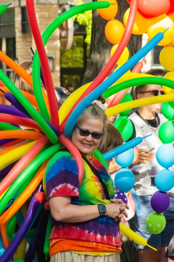 A participant of the Pride Parade smiles down while carrying a dozen noodle baloons and wearing a rainbow tie-dye shirt in Fort Collins, CO, on Thursday, June 1, 2023.