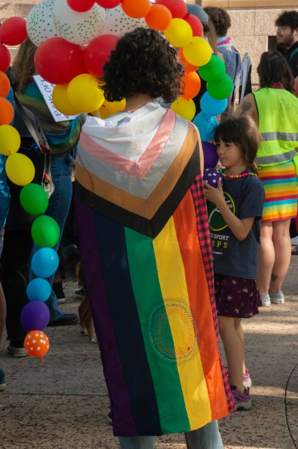 A flag is drapped accros the back of a Pride participant in Fort Collins, CO, on Thursday, June 1, 2023.