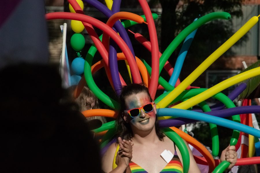 Chant-leader, Aza Rose, smiles at the camera, completely outfitted in rainbows in Fort Collins, CO, on Thursday, June 1, 2023.