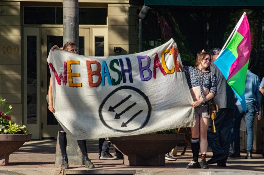 A banner reading WE BASH BACK is held up by Pride participants on the corner of College Ave. and Mason St. in Fort Collins, CO, on Thursday, June 1, 2023.