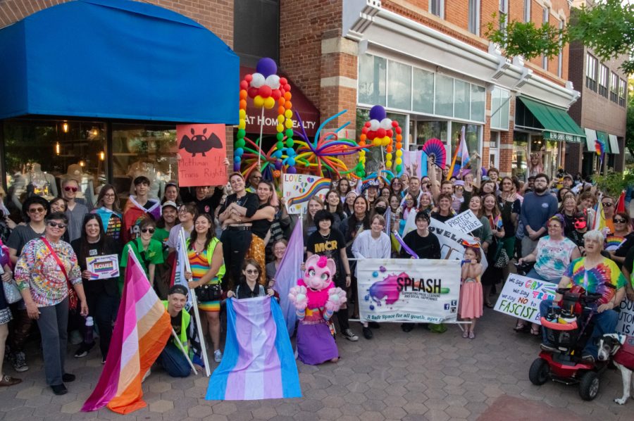 Pride March participants pose with flags and banners in a group of over 70 people in Old Town Square June 1.