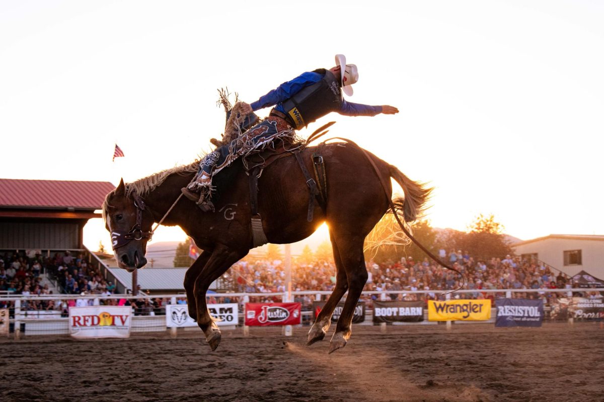 A saddle Bronc rider competes in the Gunnison Colorado Professional Rodeo Cowboys Association 123rd annual Cattlemens Days Patriot Night Rodeo July 14.