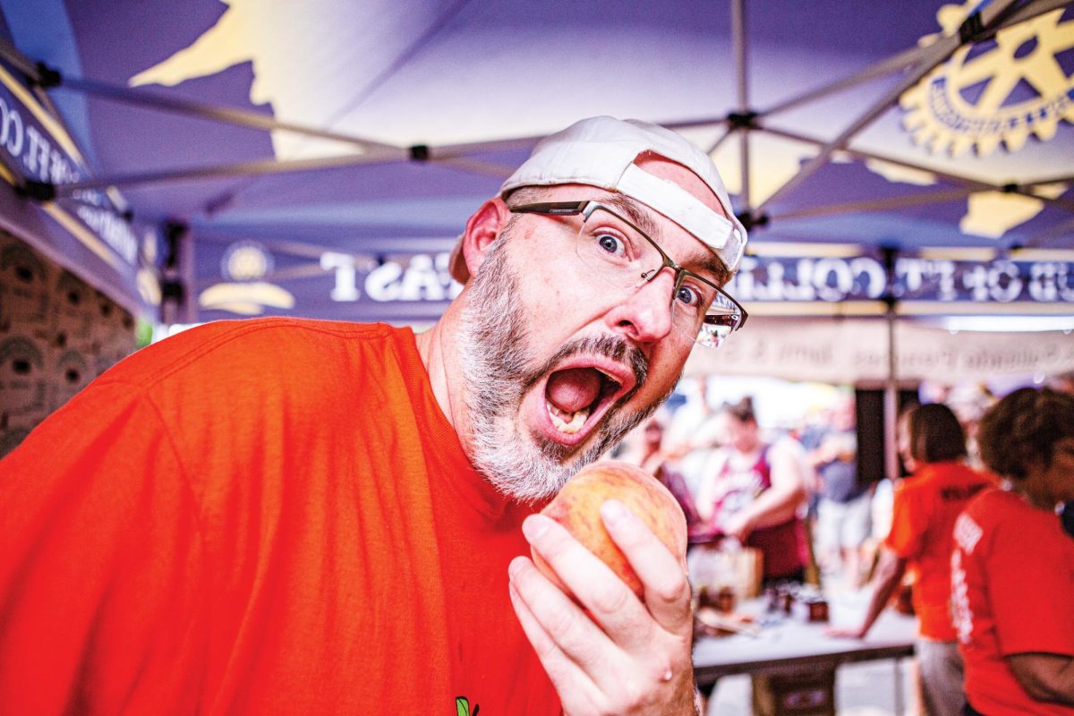 A Fort Collins resident goes in for a bite of a fresh peach Aug. 19. Presented by the Rotary Clubs of Northern Colorado, the Peach Festival was put on by local businesses and organizations. The festival took place in Civic Center Park and helped raise funds for the Imagination Library, a program that donates books to children in Larimer County.