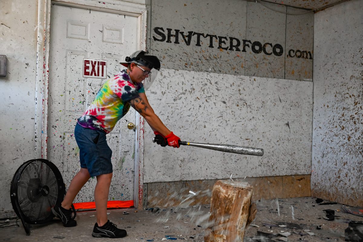 Shatter Rage Room owner Caitlin Nelson smashes a glass vase.