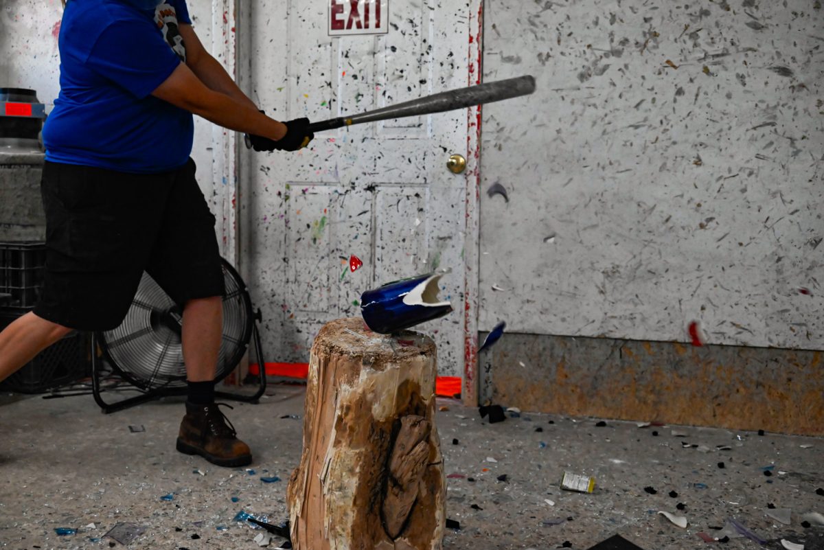 Corina Lee smashes a decorative blue and red vase at Shatter Rage Room in Fort Collins.