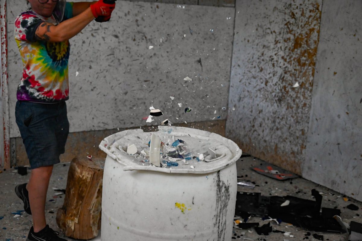 Shatter Rage Room owner Caitlin Nelson demolishes glassware.