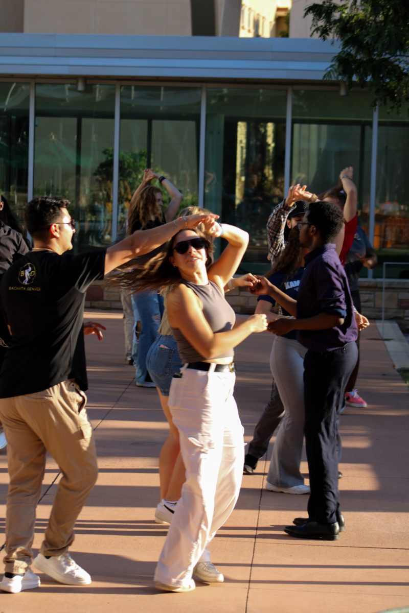 Colorado State University students join in to get a free Bachata dance lesson during the National Latinx Heritage Month launch at the Sutherland land Garden Sept. 13. One of the dancers from Bachata Denver elegantly twirls one of the volunteers during the dance. 