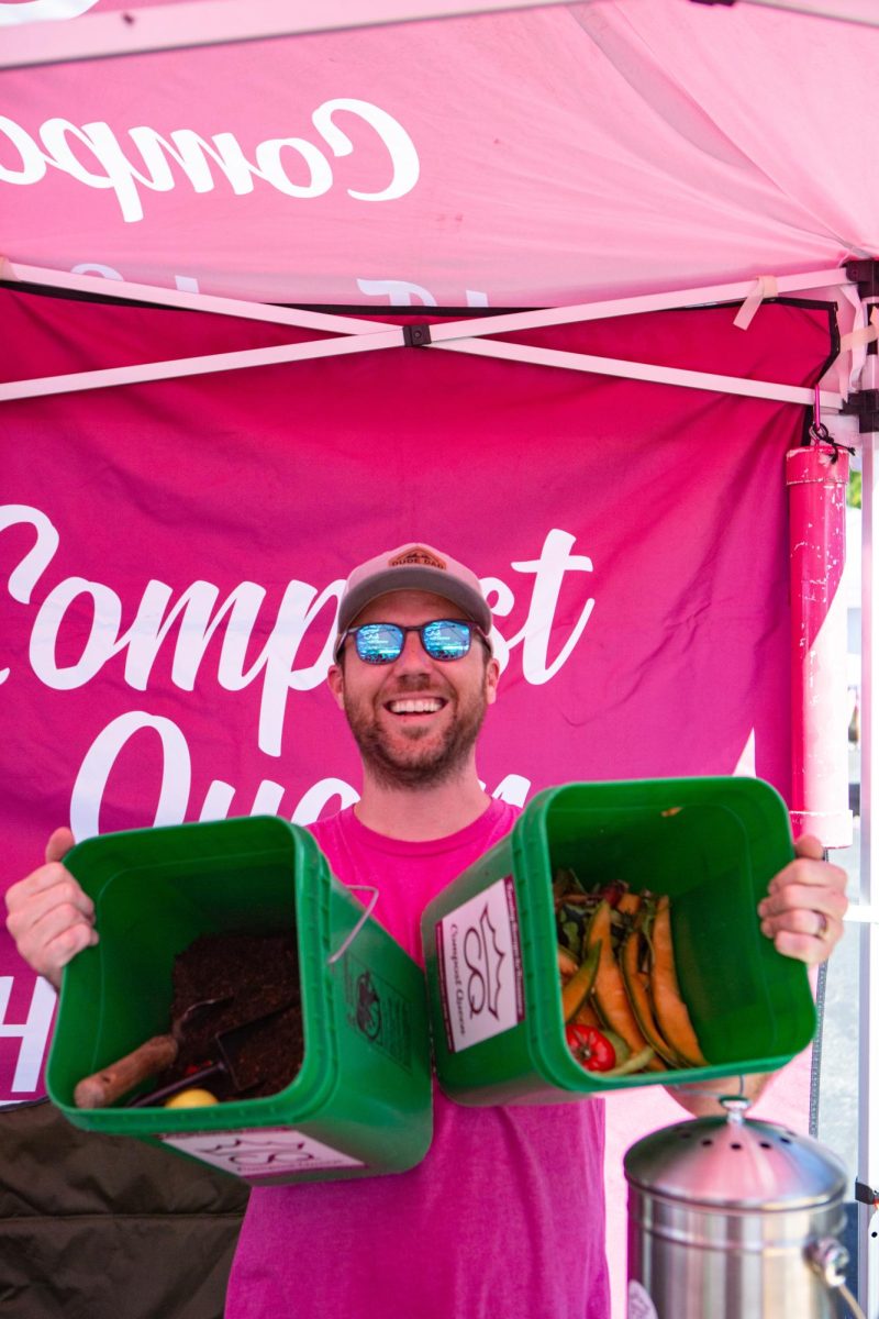 Partial-owner of Compost Queen Max Poling holding two compost bins at the Fort Collins Farmers Market located at the Ace Hardware parking lot Sep. 17. "My wife Jaime and I started composting in our own backyard," Poling said, "We were actually having a hard time doing it by ourselves but when our neighbors started asking for us to compost for them, we couldn't say no." Photo by River Kinnaird.