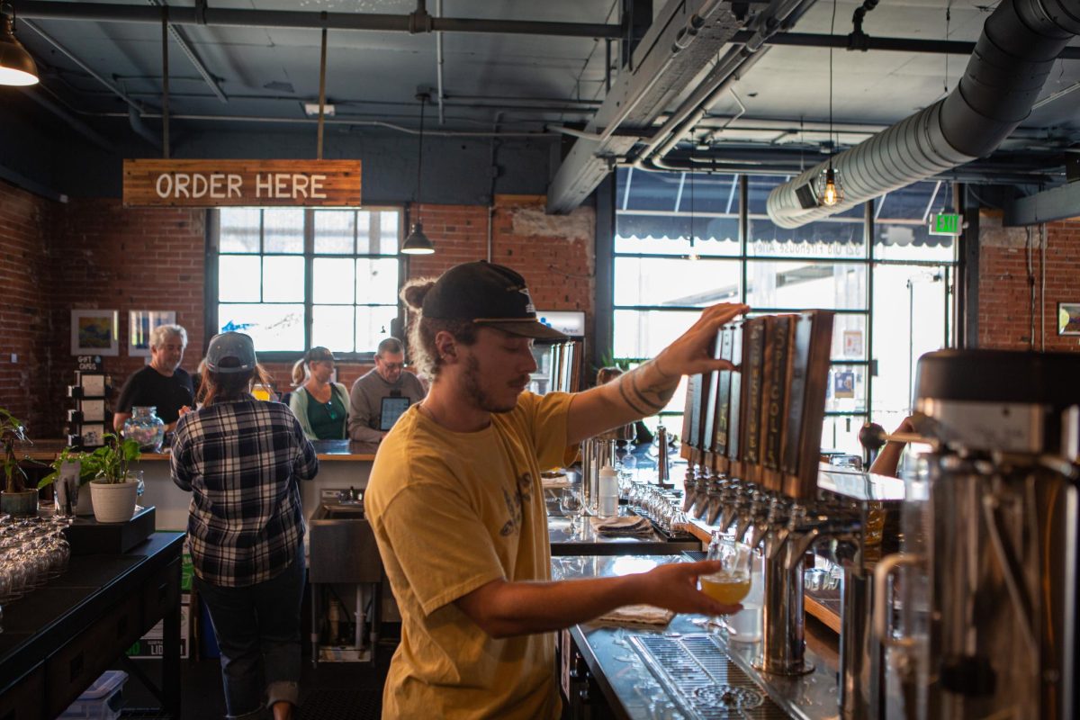 Founding Employee Zach Farrin pours a beer for a customer during Salt Road Brewing's Oktoberfest Sep. 23. "The best part about this place is that all of us (employees) got to come in before opening and really work with the management to build a great brewery," said Farrin, "It feels like a big family, we all want this to succeed."