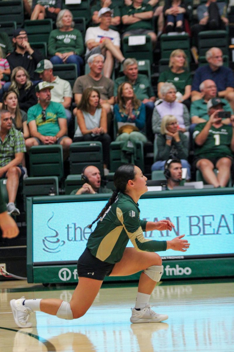 Kate Yoshimoto (18), a Colorado State defensive specialist, bends down preparing for an oncoming hit from San Diego State University Sept. 28. Yoshimoto performed 15 digs, the highest amount by a CSU player.