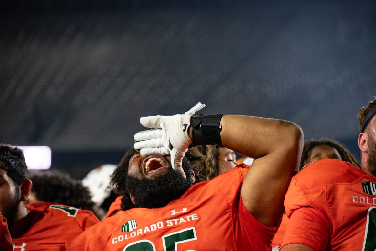 Redshirt sophomore Cameron Jackson (65) cheers as the CSU marching band plays the university’s fight song.