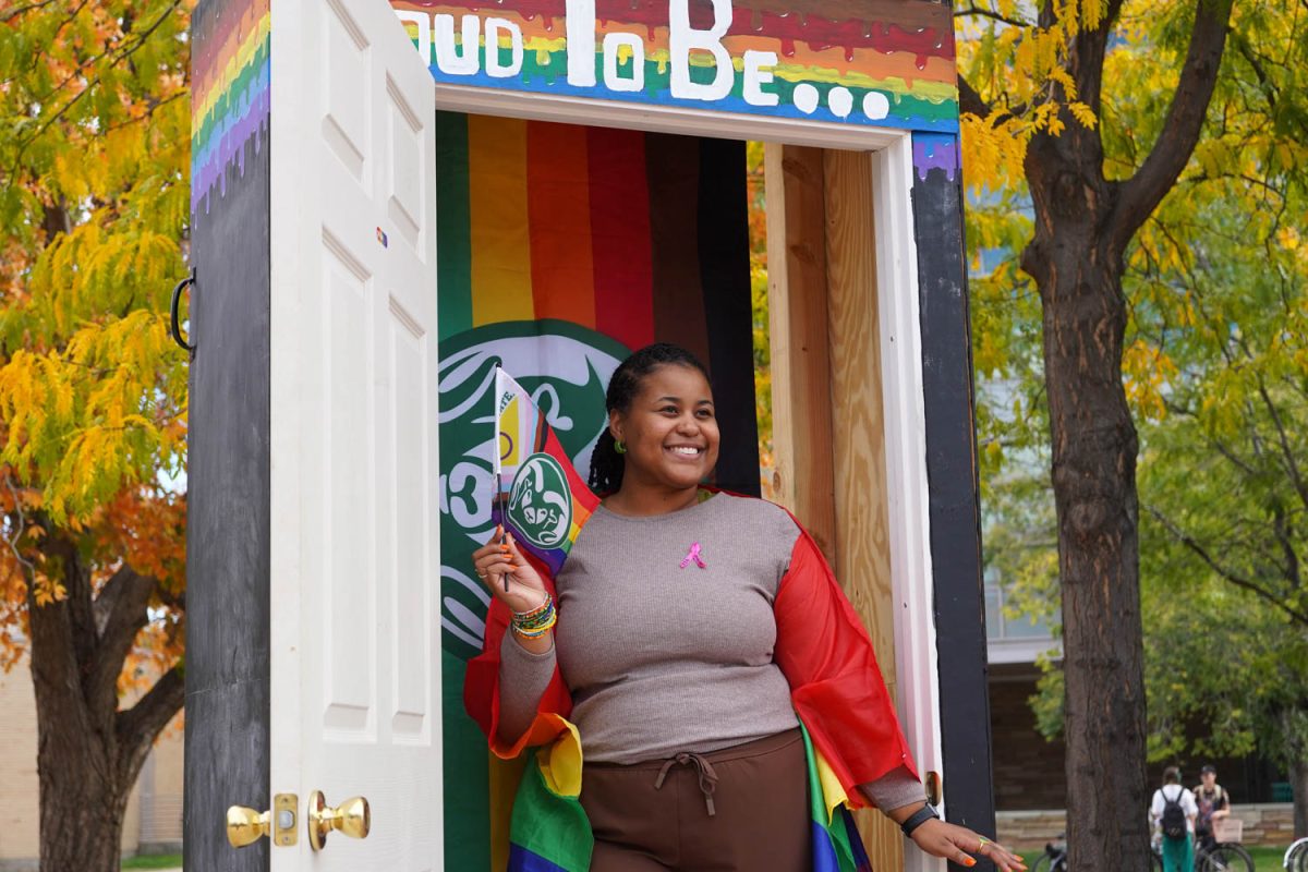 Shelby Davis poses in the photo booth with a Colorado State University pride flag Oct 11.