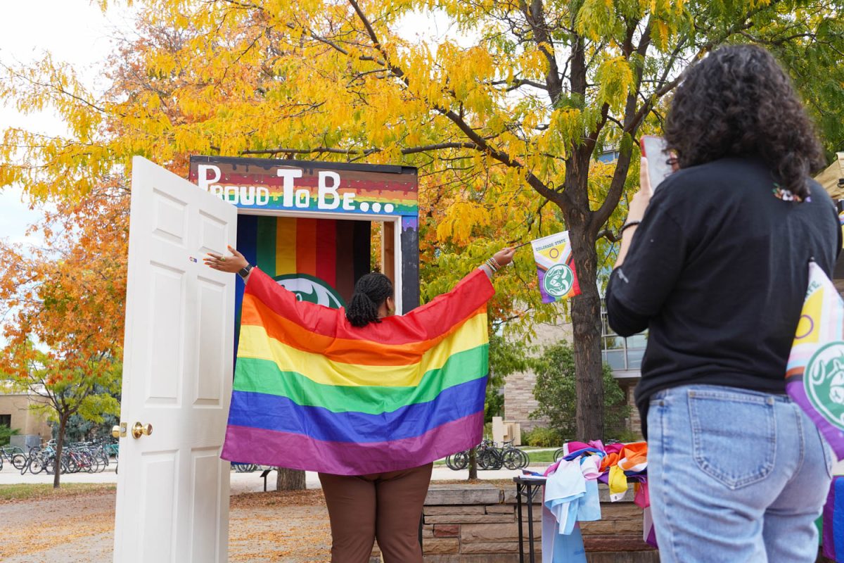 Shelby Davis poses in the photo booth with a Colorado State University pride flag Oct 11.