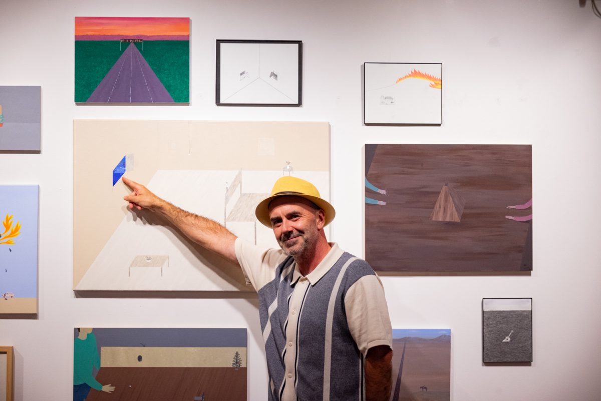 Aitor Lajarin-Encina, a painting instructor at Colorado State University, points at a small detail in one of his paintings shown in the Directions Gallery.