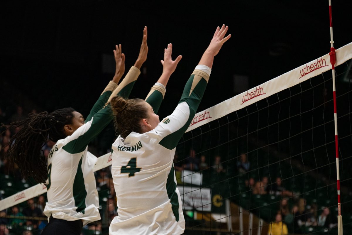 Colorado State University middle blocker Naeemah Weathers (9) and setter Emery Herman (4) block the ball.