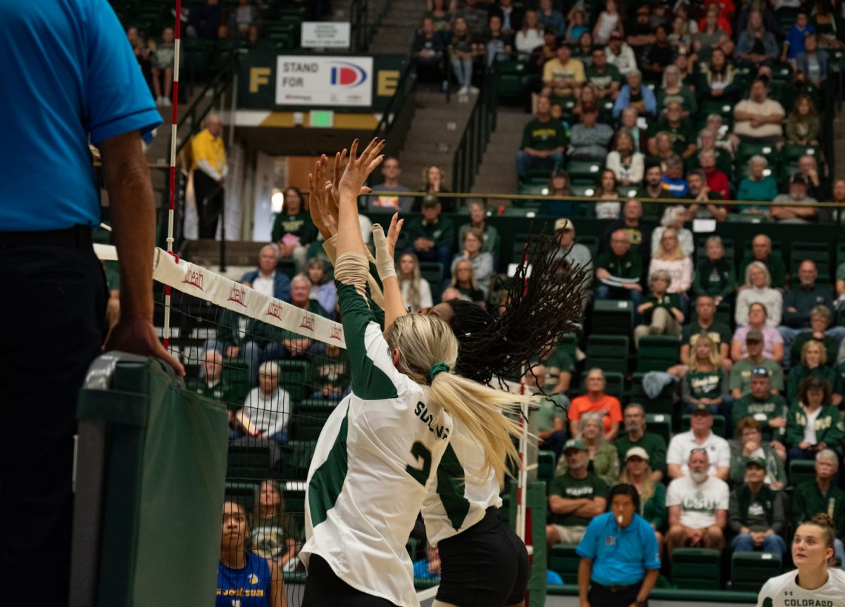 Colorado State University middle blocker Naeemah Weathers (9) and outside hitter Annie Sullivan (2) block the ball.