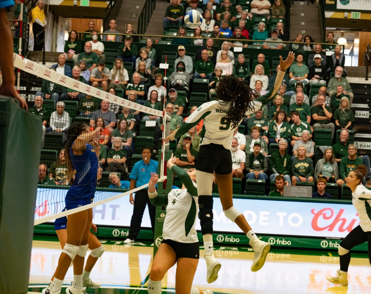 Senior Naeemah Weathers (9) leaps up to spike the ball over the net.