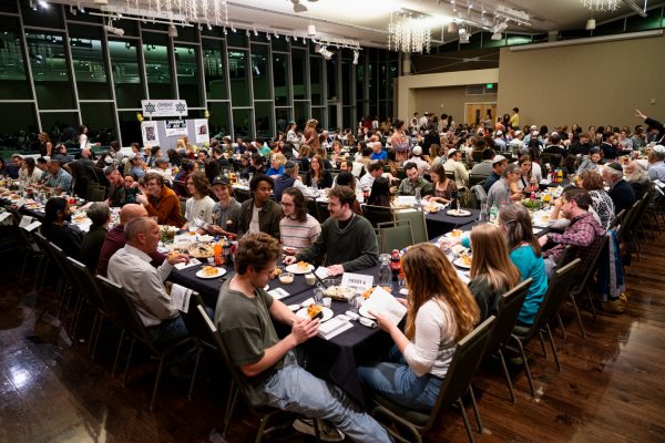 A large crowd of people sitting at tables and eating.