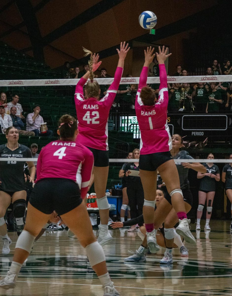 Malaya Jones (1) and Karina Leber (42) jump up to block the ball from opponents Utah State Oct. 26. Colorado State University volleyball hosted a pink out game to show their support for fighting for a cure for cancer. 
