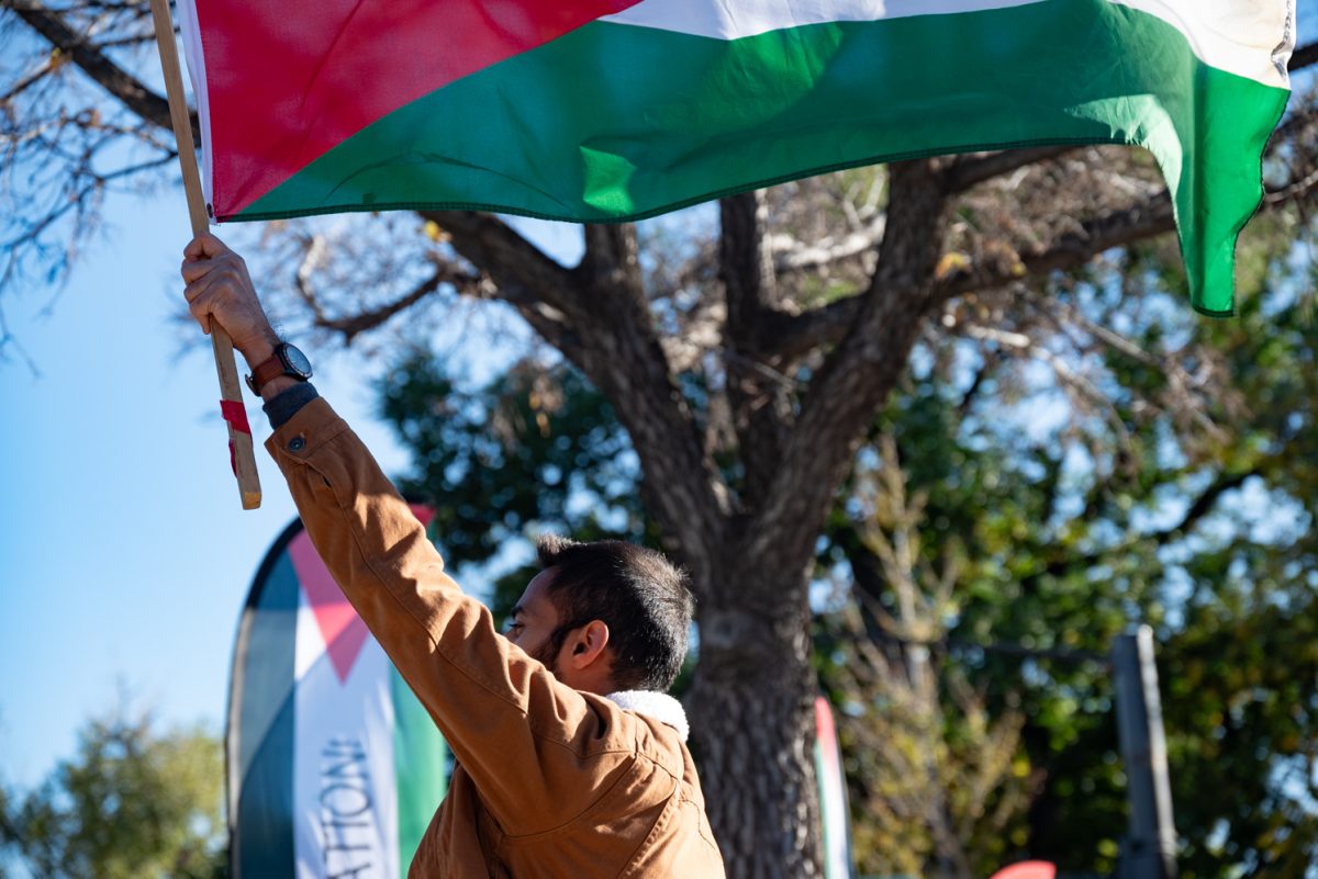 [name not provided] A protestor holds up a Palestinian flag during a "Freedom for Palestine Protest" on College Avenue in Fort Collins.