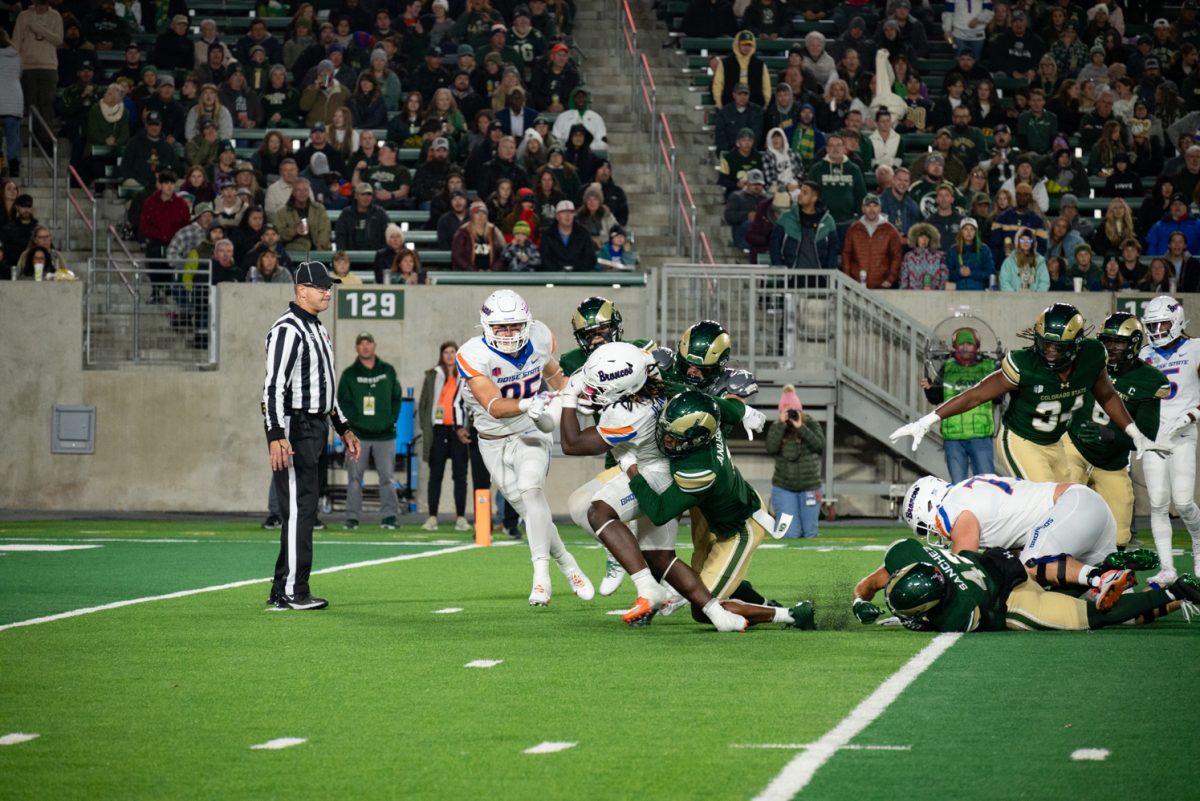 Colorado State University football players take down a Boise State player.