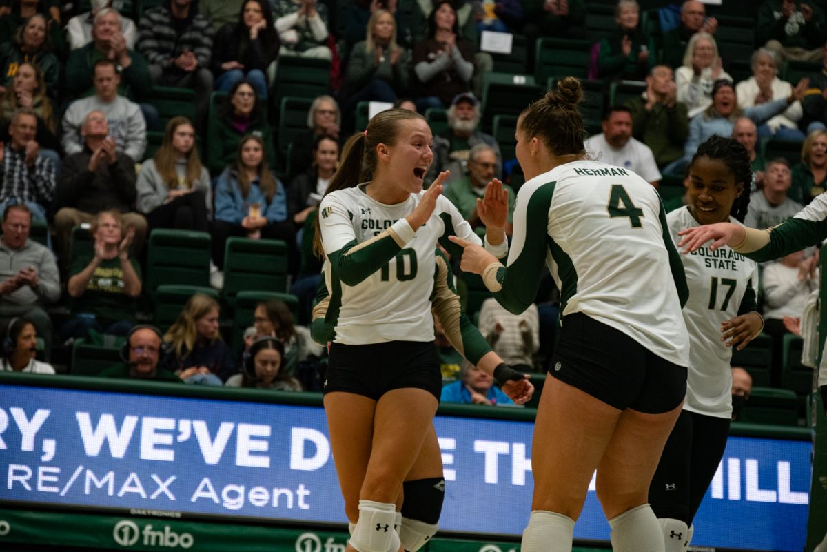 Graduate student Anna Porter (10) and senior Emery Herman (4) celebrate after they score a point against Boise State.
