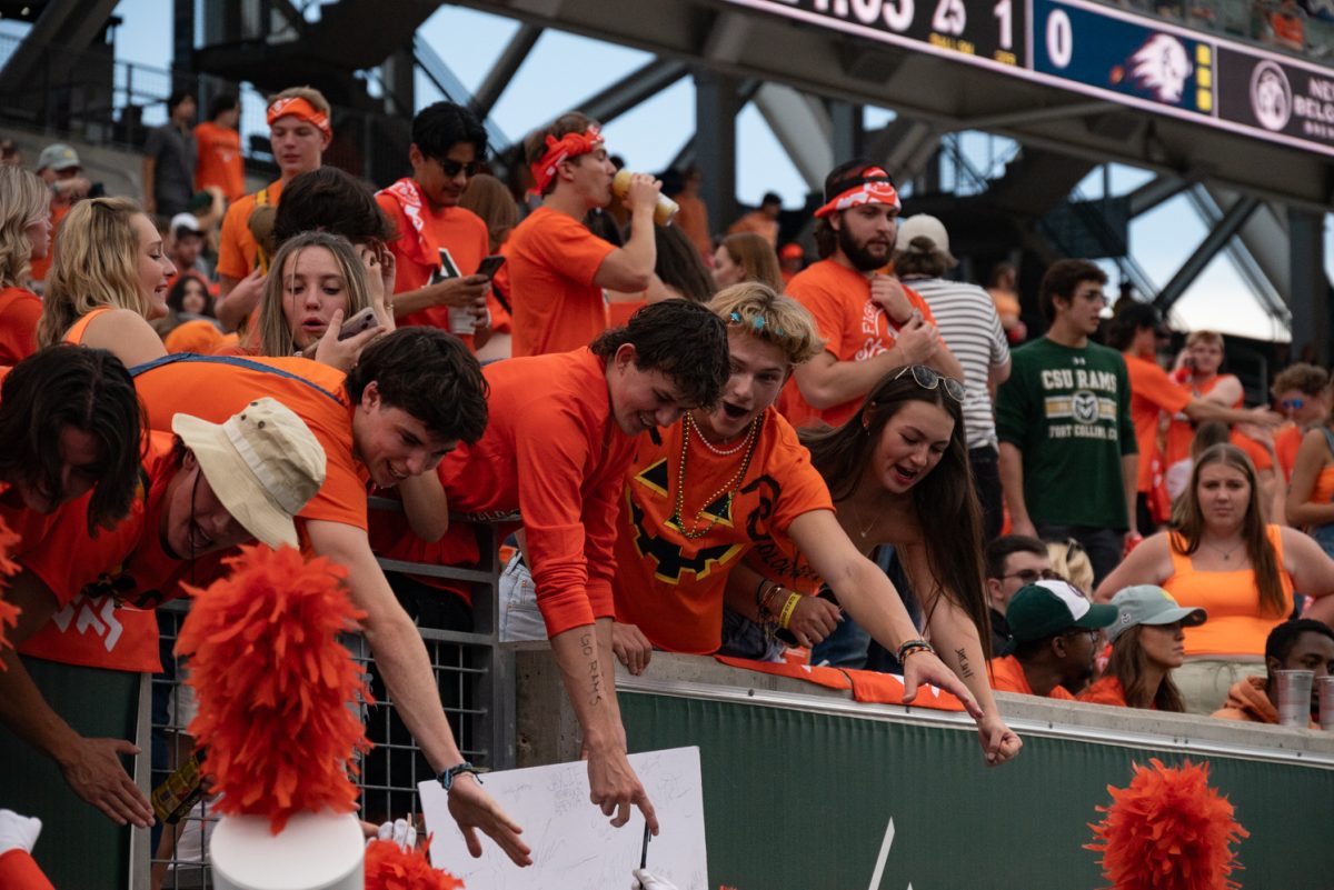 Colorado State University students high-five their marching band performers.