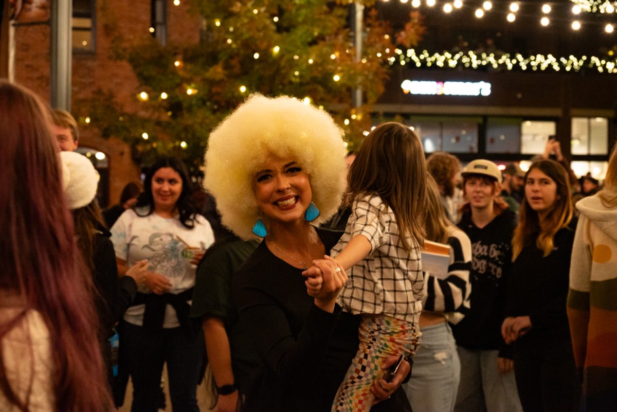 Kristi Lovette smiles and dances to live music at the Downtown Holiday Lighting Ceremony in Old Town Square, Fort Collins.