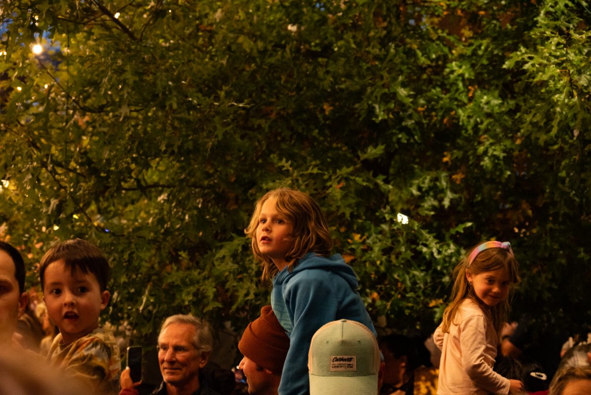 Hendricks Reisingei watches the holiday lights turn on from Eric Reisingei's shoulders at the Downtown Holiday Lighting Ceremony in Old Town Square, Fort Collins.