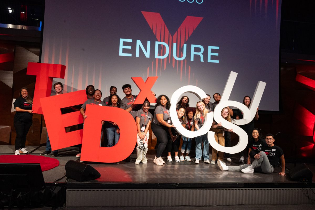 Colorado State University students who helped run this year's TedxCSU event pose with the letters that spell out 'TedxCSU' on the stage.