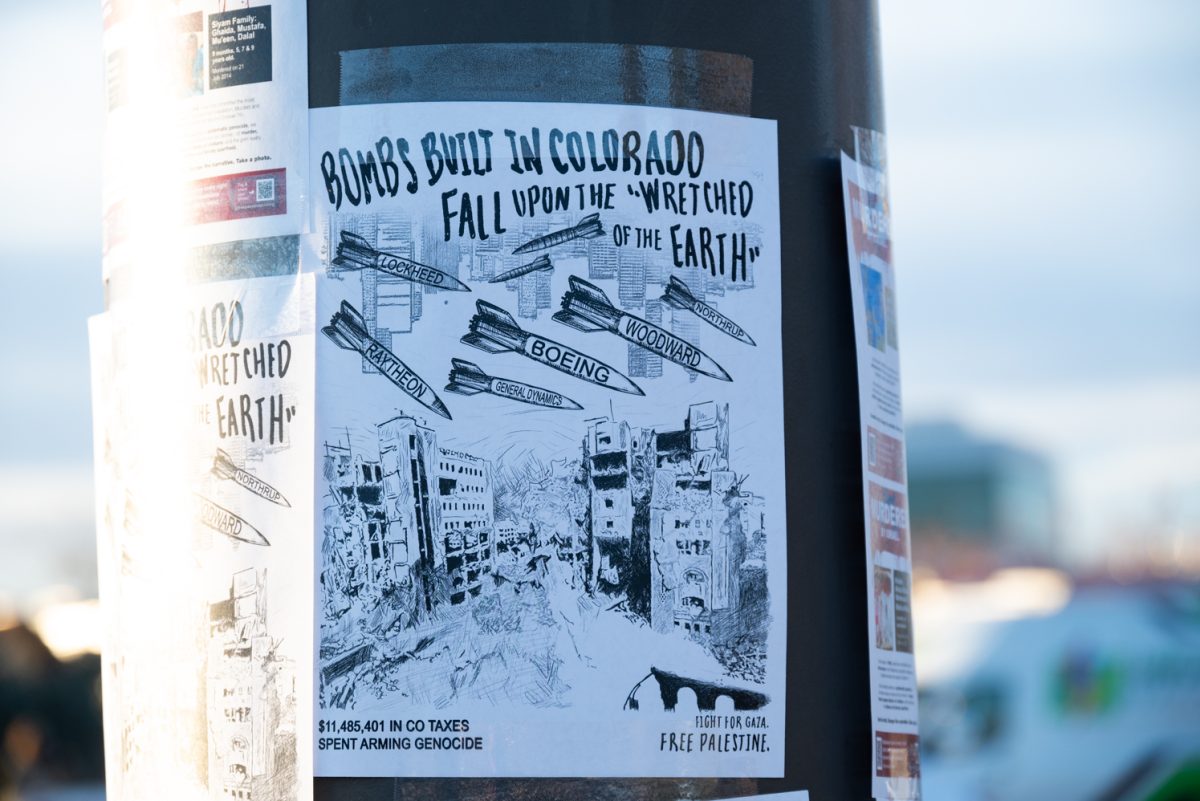 Posters cover a pole across the street from the "Die-In at Woodward" protest.