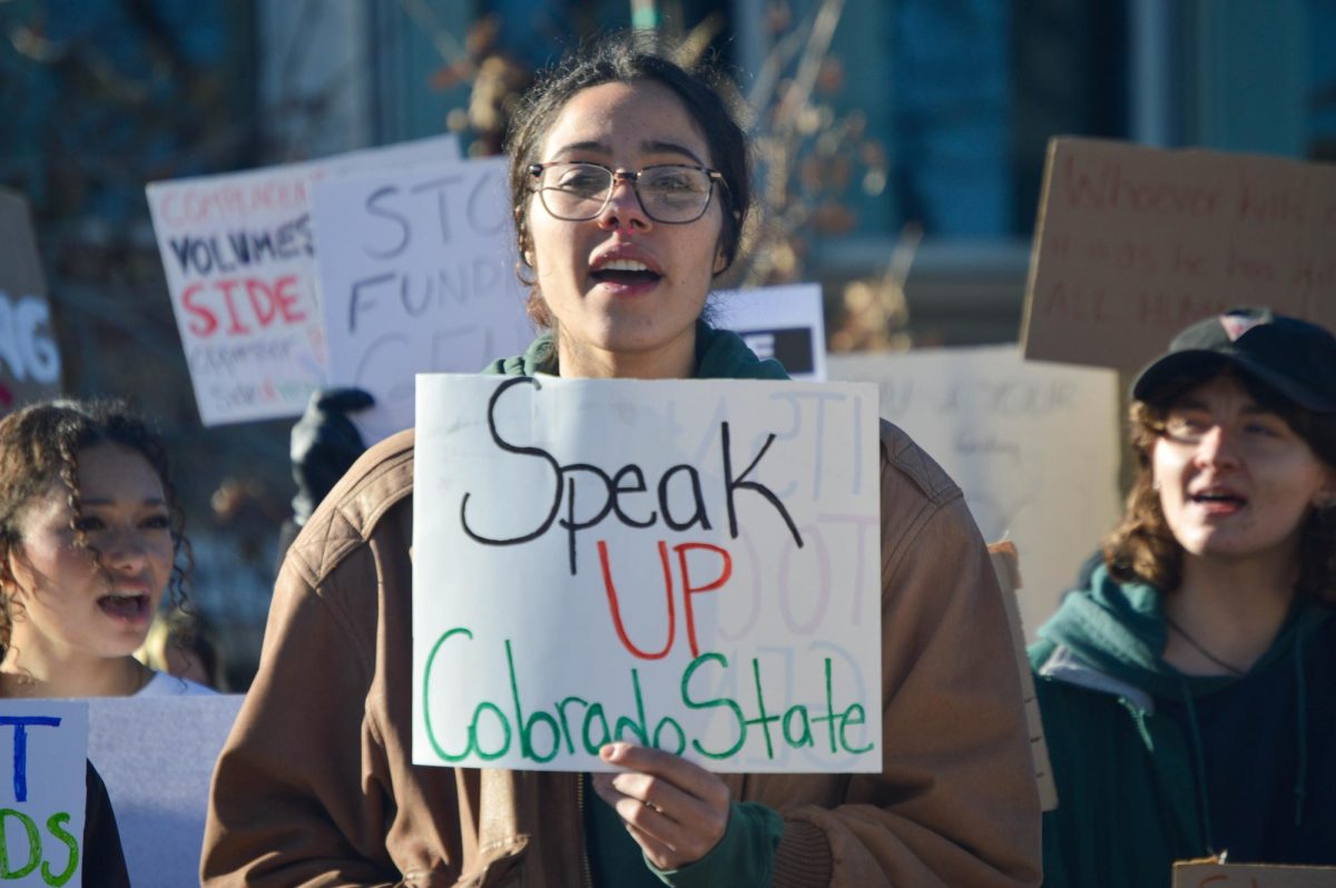 A protester holds a sign reading, Speak up Colorado State.