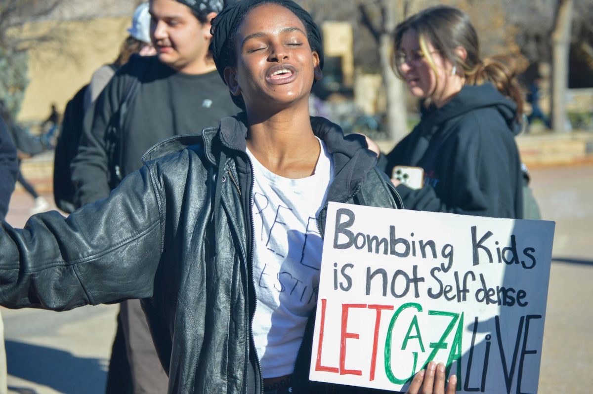 A protester holds a sign reading, Bombing kids is not self-defense/Let Gaza live.