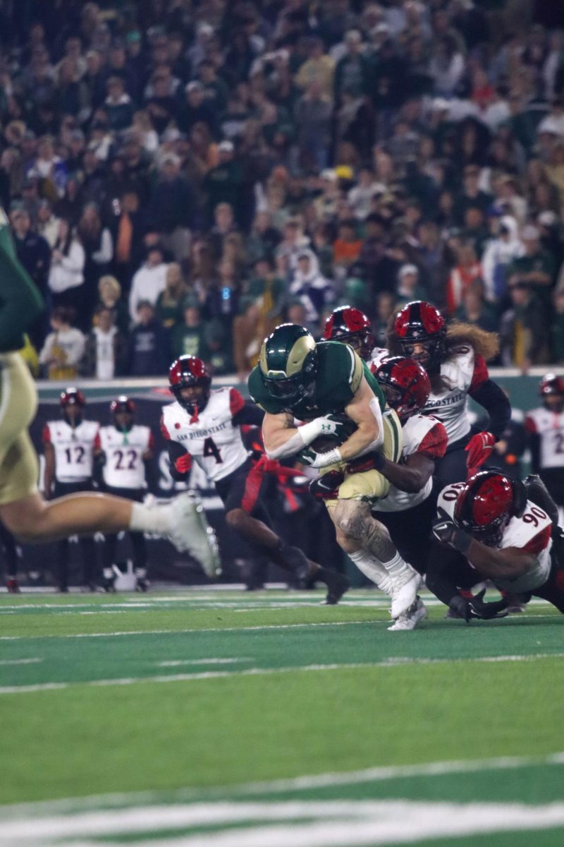 Colorado State University No.28, Vann Schield gets taken down by a San Diego State University player at the military appreciation game against San Diego State University, CSU won 22-19.