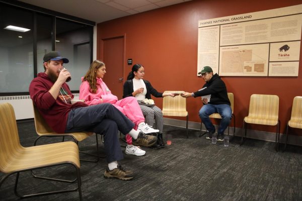 Colorado State University students pass around the Food for Thought core agreements sheet before reading them together and talking to each other Nov. 16.