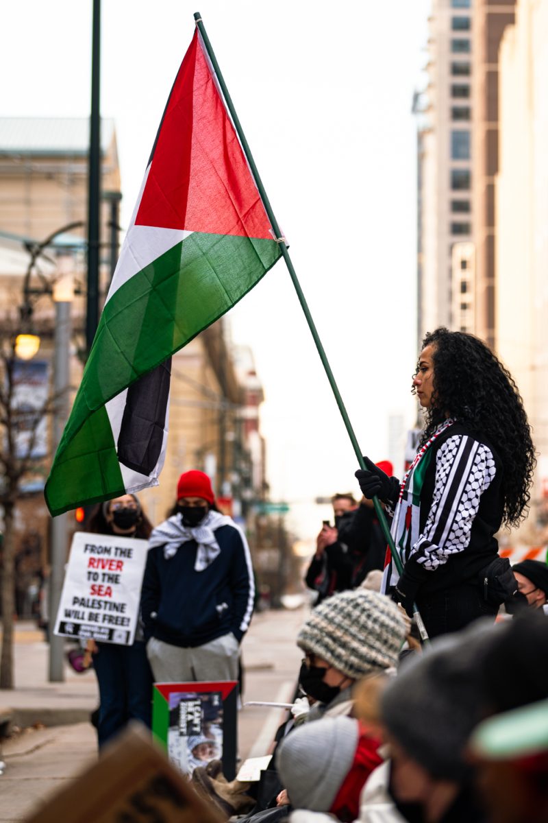 A protester in support of Palestine holds a Palestinian flag outside the Denver Convention Center for a “Shut down the JNF” picket Dec. 1.