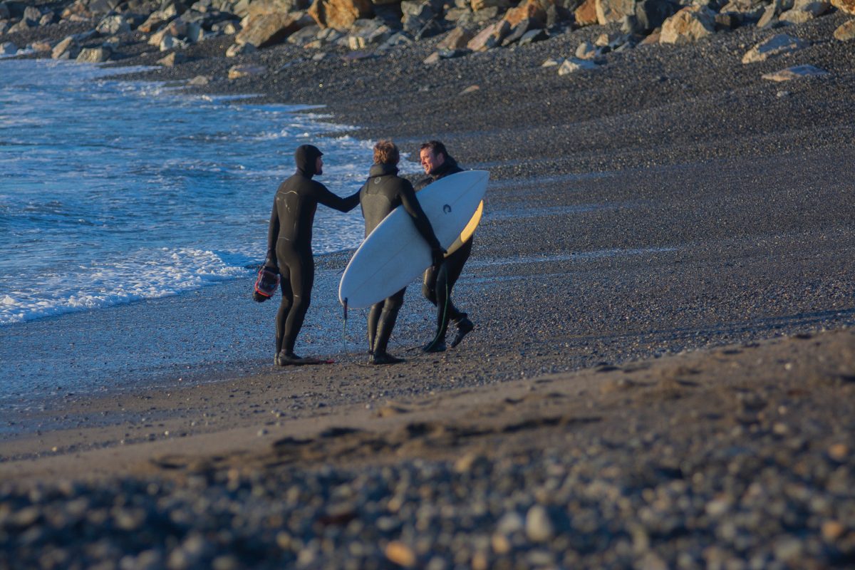 A Surf photographer meets with two surfers after their session at Bass Beach in Rye New Hampshire. (Dec 20,2023)