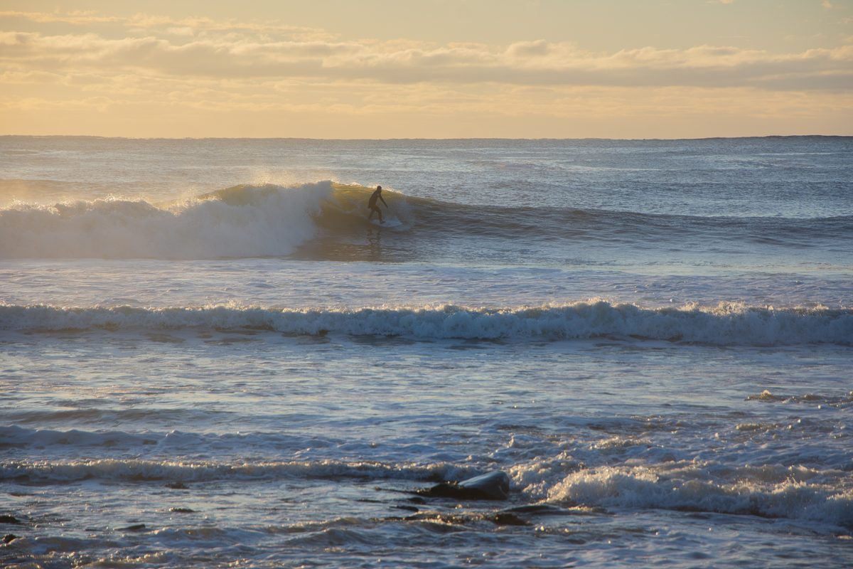 A surfer catches the swell of a wave to ride into shore at Bass Beach in Rye, New Hampshire, Dec. 20, 2023. “Surfing is very fun and underrated here in New Hampshire,” surfer Tate Kurani said. "It is even better now because of the winter storms lately." Many storms have been hitting the
coast of New Hampshire, causing waves up to 15 feet tall, which makes peak conditions for surfers 
like Kurani.